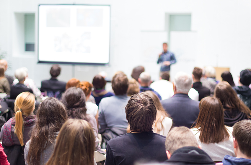 Participants at a conference listening to a speaker.