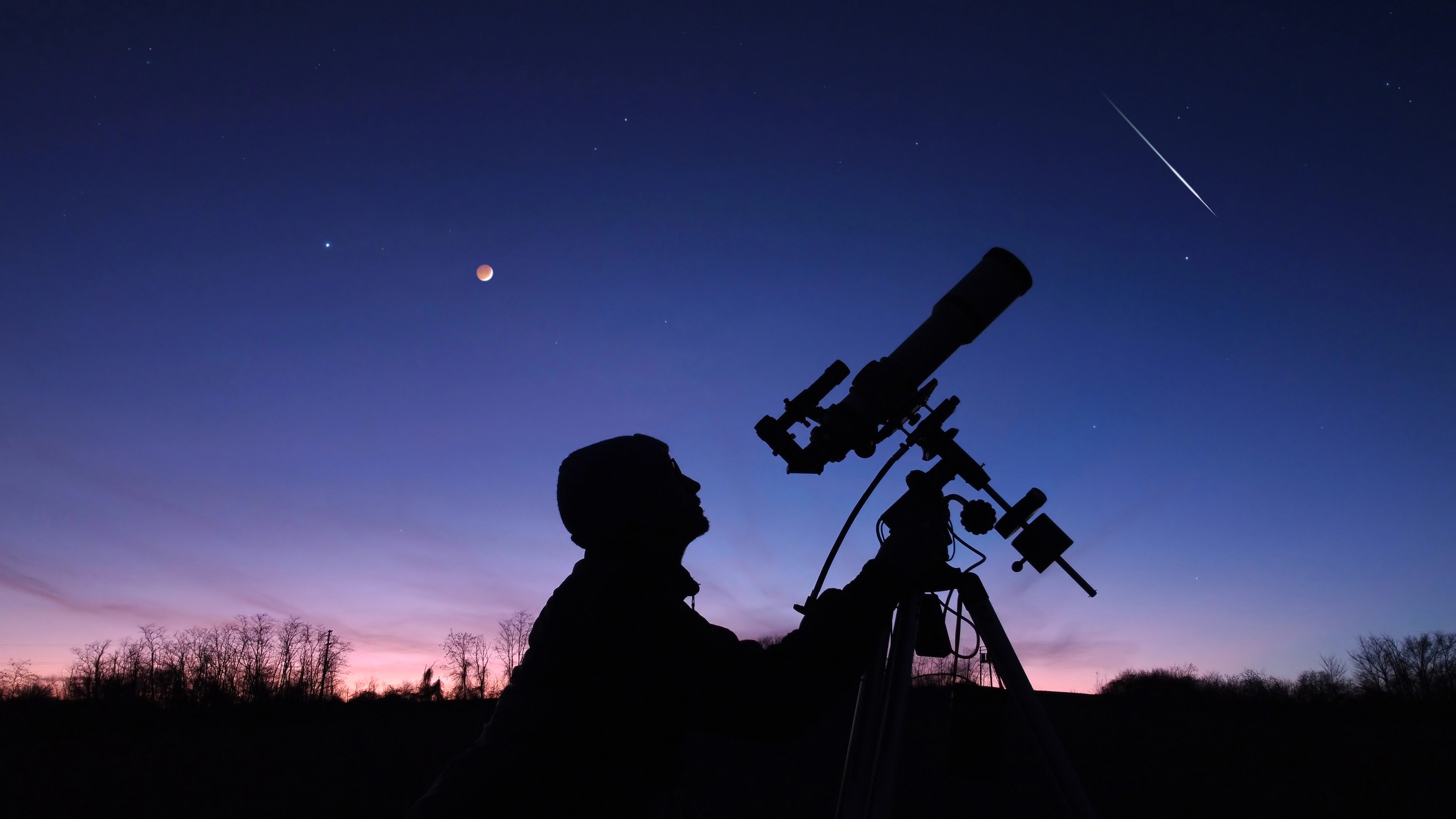 Silhouette eines jungen Mannes, Teleskop und Landschaft unter dem Abendhimmel.
