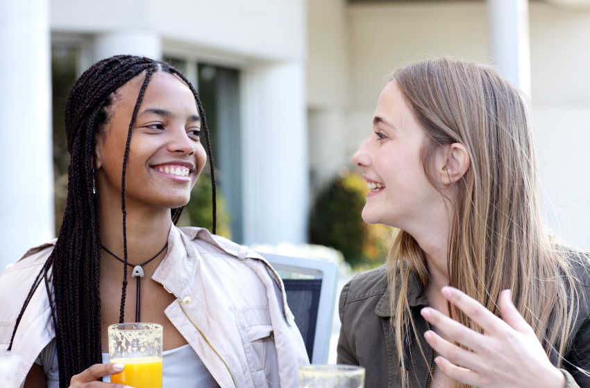 Zwei Frauen unterhalten sich an einem weißen Tisch