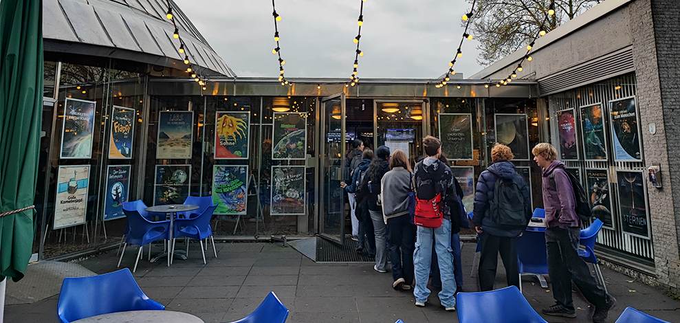 Beitragsbild SPW25b Jugendliche stehen in einer Schlage vor der Türe des Planetariums.